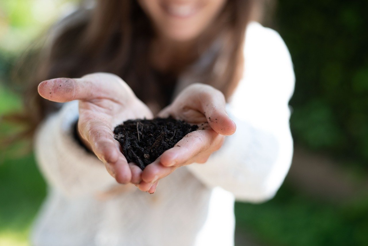 Sacchetto biodegradabile con fondi di caffè e scarti organici per compostaggio domestico.